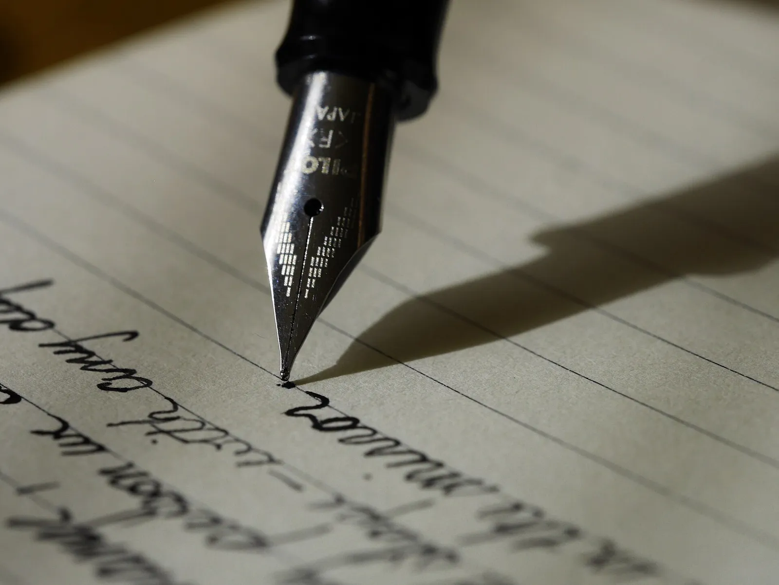 A fountain pen writing on lined paper